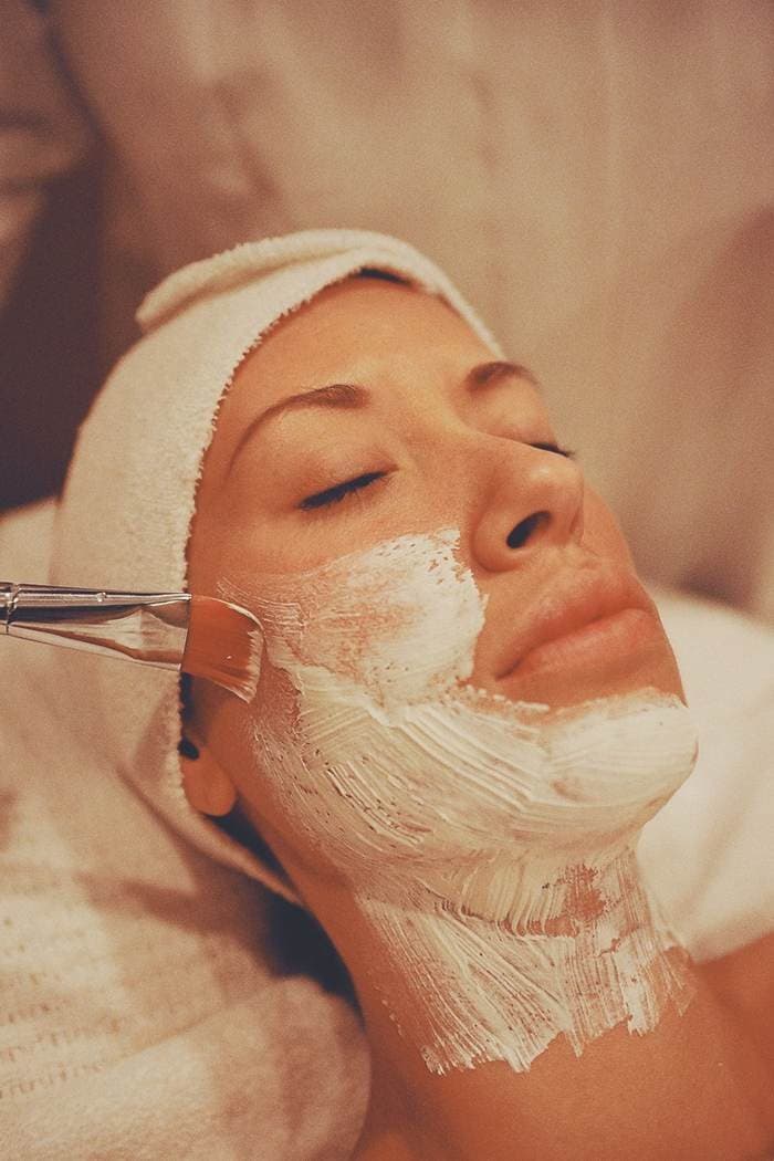 Profissional da Clínica Lumière realizando tratamento facial
